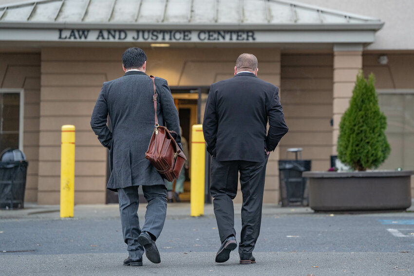 Lewis County PUD Commissioner Michael Kelly, right, walks to the entrance of the Lewis County Law and Justice Center acompanied by his lawyer ahead of making his first appearance in Lewis County Superior Court on Monday, Dec. 2.