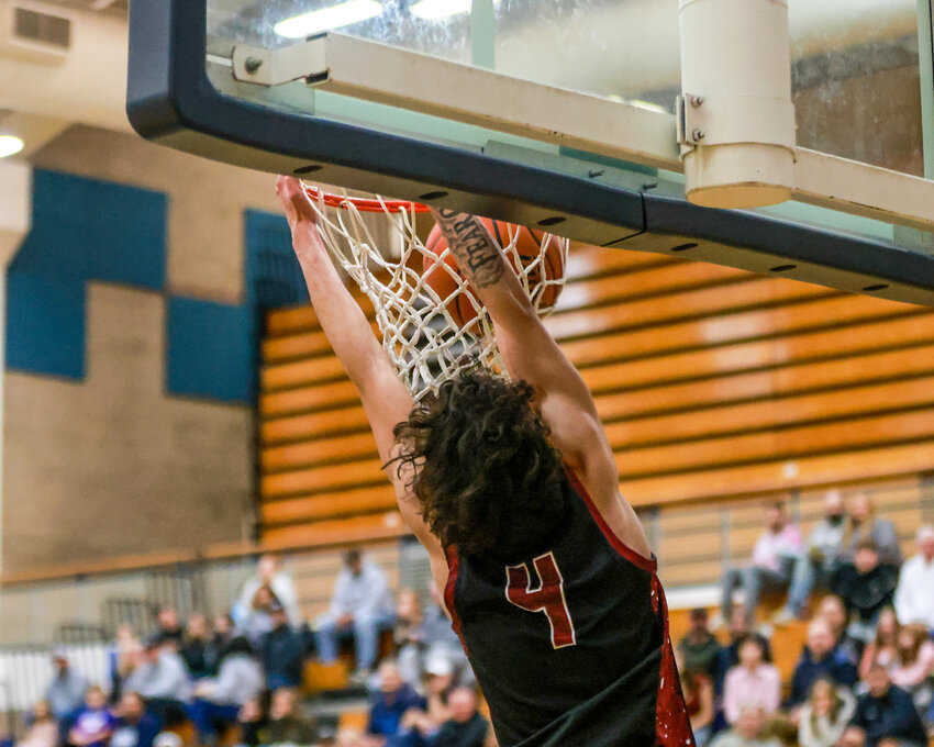 Malachi Patton, a 6-foot-tall guard for the Prairie Falcons, slams it home with two hands and hangs onto the rim during the first half of the Falcons&rsquo; 68-56 loss to the Skyview Storm on Thursday, Dec. 12.