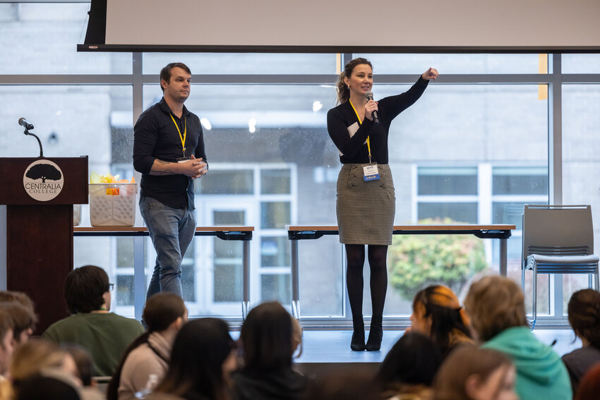Naomi Robb, vice president of Kiddin' Around, points to a group of students during the Lewis County Business Academy&rsquo;s closing ceremony in the TransAlta Commons of Centralia College on Thursday, Dec. 19.