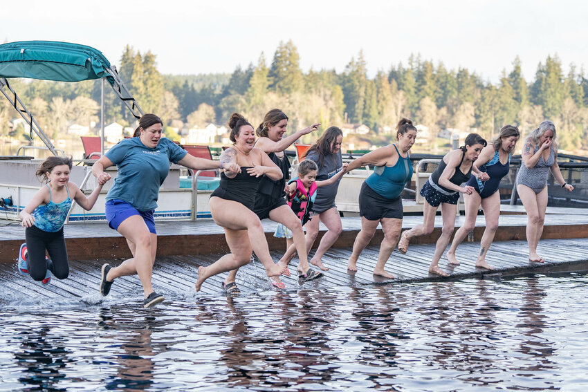Polar Plungers jump into Offut Lake from the Lady of the Lake Public House boat dock near Tenino during the annual Offut Lake Polar Plunge on New Year's Day, Wednesday, Jan. 1.