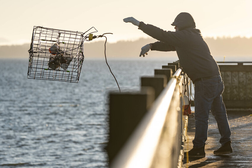Gary Doyle tosses a baited crab trap into the Willapa Bay from the Toke Point Pier in Tokeland on Friday, Jan. 17.