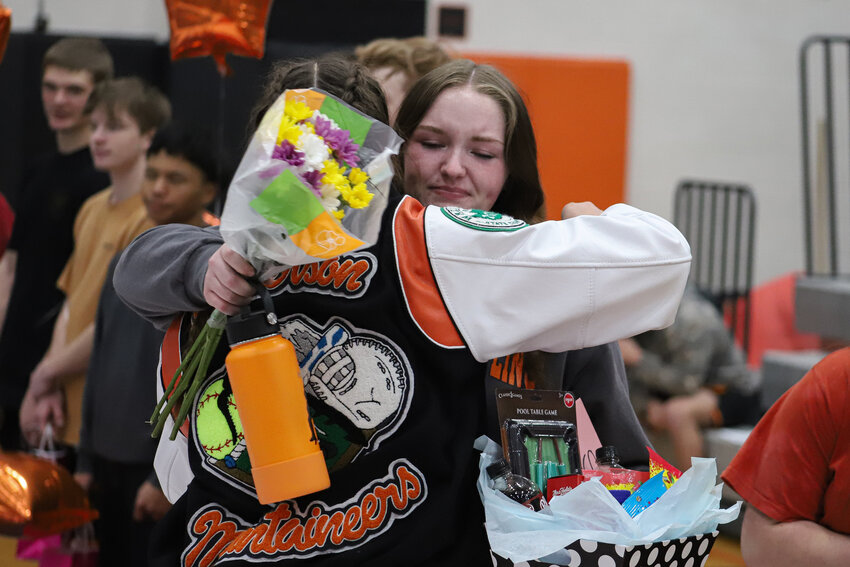 Keira Anderson, in jacket, hugs teammate Ryleigh Cruse as Anderson is honored during Rainier's wrestling senior night on Jan. 23.