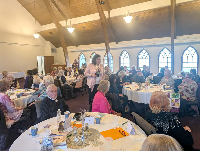 Kay Mills, Centralia/Chehalis Women&rsquo;s Connection chair, hands out a card during a luncheon.
