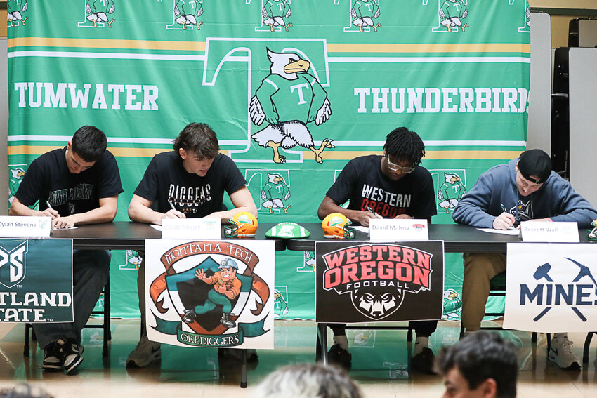 From left to right, Tumwater's Dylan Stevens, Cash Short, David Malroy, and Beckett Wall sign their National Letters of Intent to play collegiate football during a signing ceremony at Tumwater High School on Feb. 5.