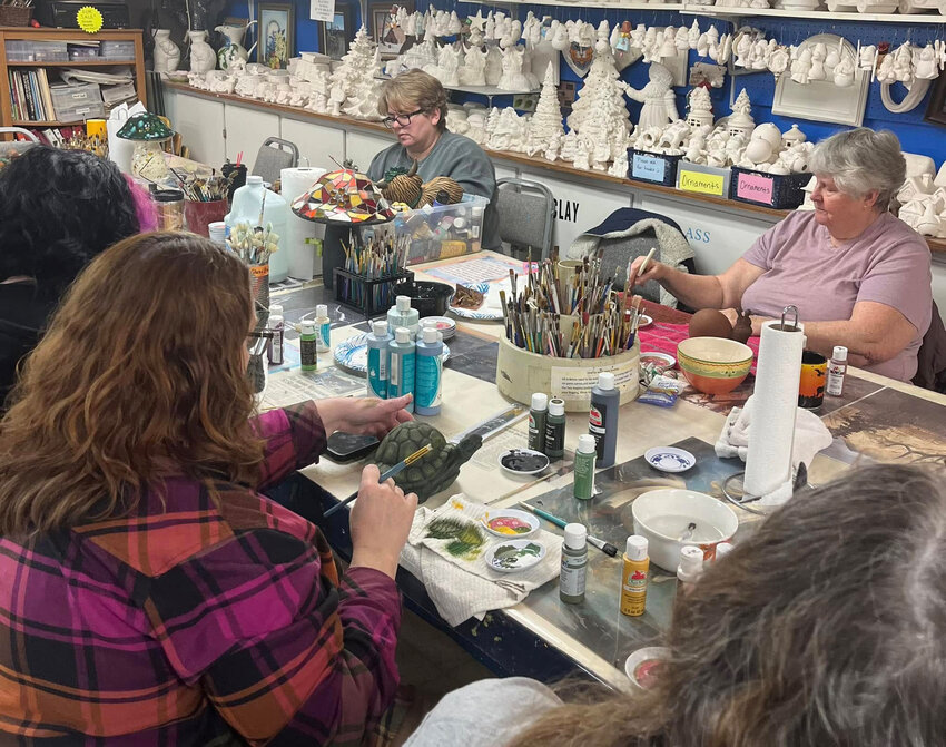 A group works on dry brushing during a class at Out Back Ceramics and Art Studio.