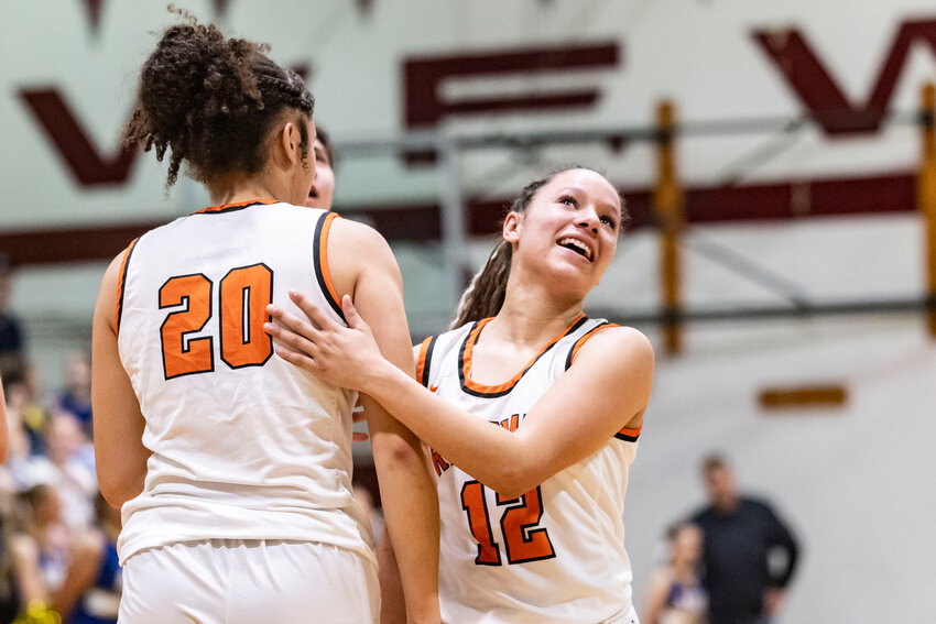 Rainier&rsquo;s Jazzlyn Shumate (12) smiles at the scoreboard as she hugs Janess Blackburn (20) before officially winning the 2B District 4 Championship against Adna at W.F. West High School in Chehalis on Saturday, Feb. 22.