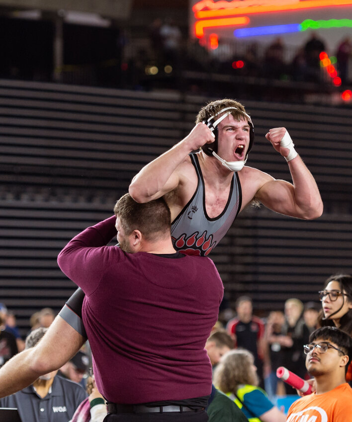 A coach lifts W.F. West&rsquo;s Tucker Land into the air after Land won the 2A Boys 190-pound title at Mat Classic XXXVI on Saturday, Feb. 22, at the Tacoma Dome. (Joshua Hart/For The Chronicle)