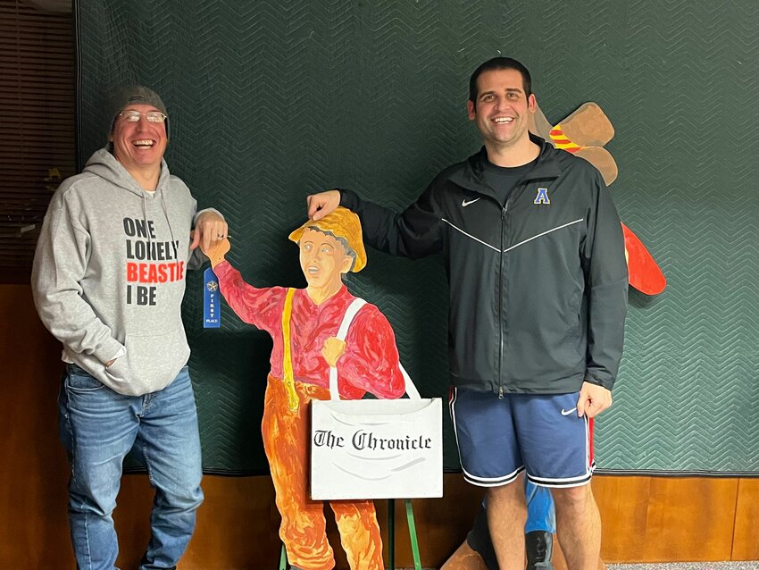 Former Morton-White Pass boys basketball coach Chad Cramer and Adna girls basketball coach Chris Bannish pose with The Chronicle Newspaper boy in The Chronicle office in Centralia.