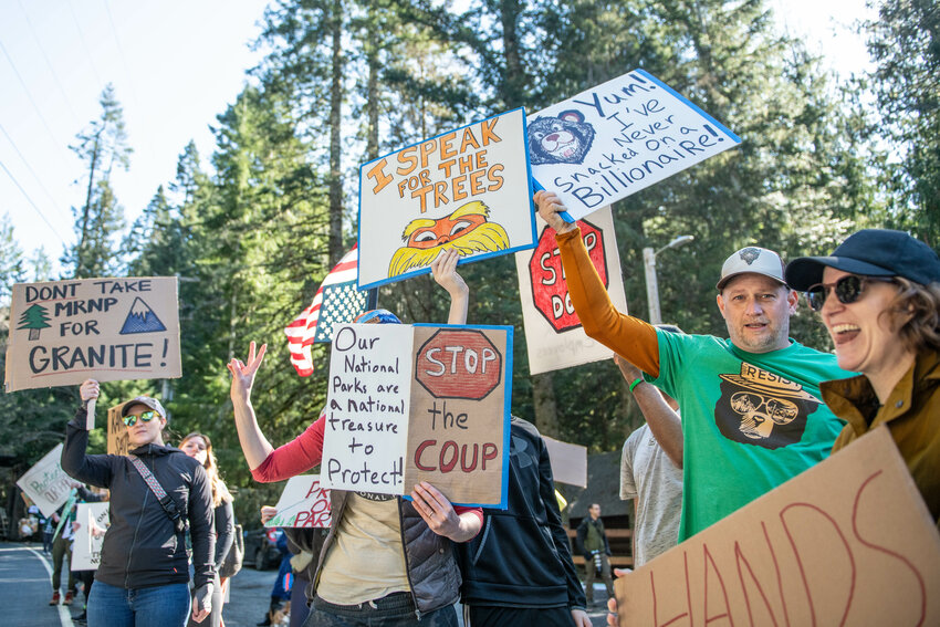 Protesters hold up signs as cars pass by during a &ldquo;Protect Our Parks&rdquo; protest along State Route 706 outside of the Nisqually entrance to Mount Rainier National Park near Ashford on Saturday, March. 1.
