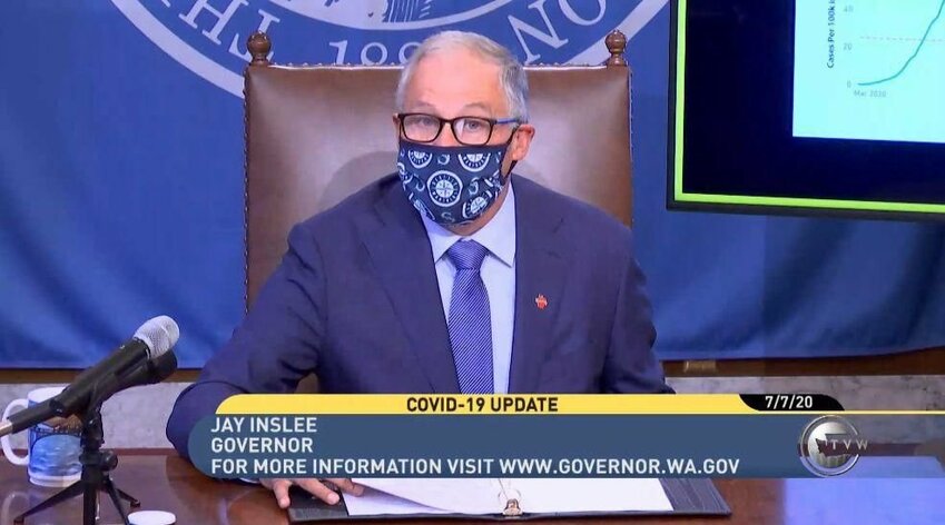 Former Washington Gov. Jay Inslee wears a mask while providing a COVID-19 update in 2020.