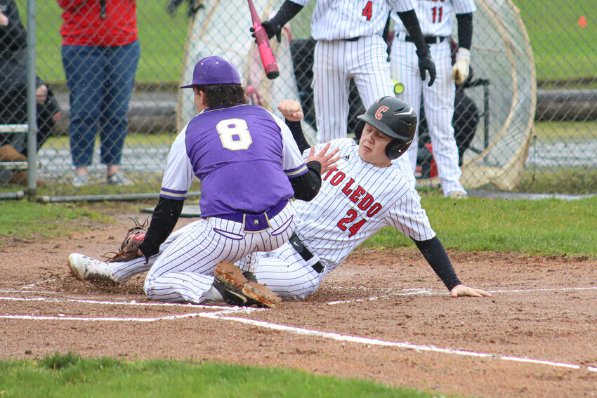 Toledo's Bode Buswell (24) slides into home past Onalaska's Desean Stewert (8) at Toledo High School on Friday, March 14.
