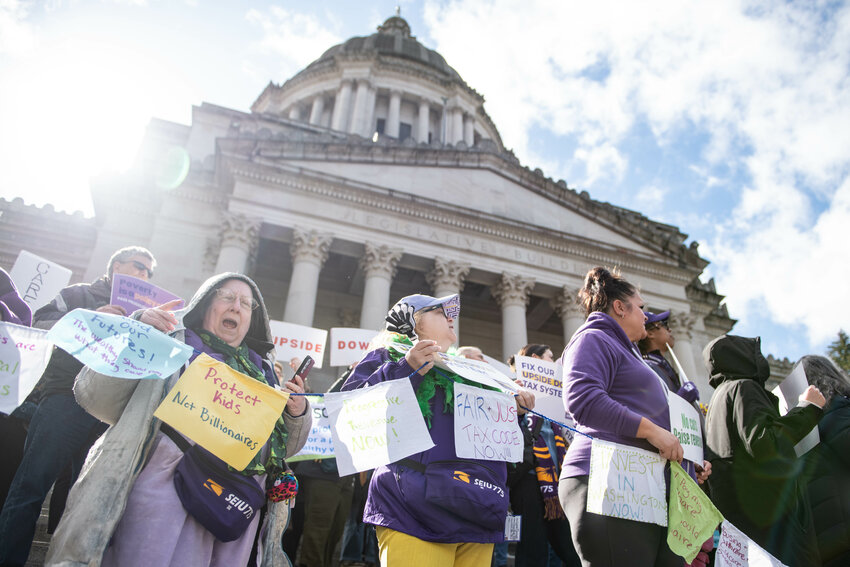 protester holds up a signs and chant during a rally opposing state budget cuts on the steps of the Washington State Capitol Building in Olymipa on Monday, March 17.