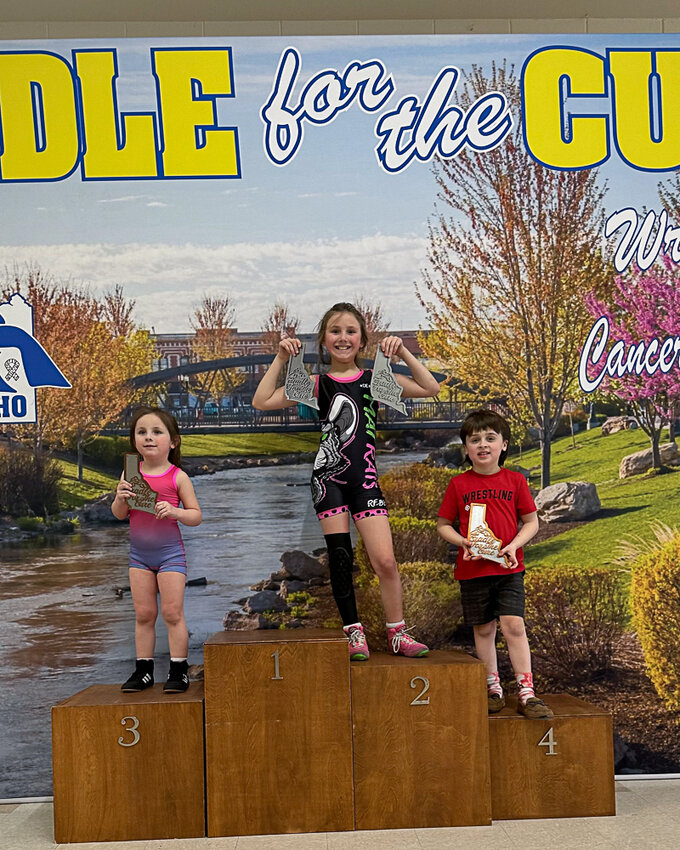 From left to right, Charlie Ojard, Addie Ojard, and Kane Ragsac pose on the podium after finishing in the top four of their respective divisions at the Cradle for the Cure Tournament in Caldwell Idaho on March 16.
