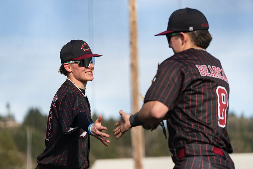 W.F. West&rsquo;s Brooks Ledgerwood, left, high fives Miles Martin during the Bearcats 10-0 win over Mark Morris in Chehalis on Tuesday, March 25.