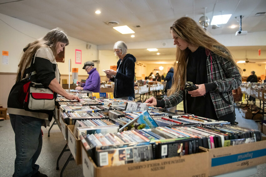 Shoppers browse a selection of CDs during the Lewis County American Association of University Women (AAUW) used book sale at the Moose Lodge in Centralia on Thursday, March 27.