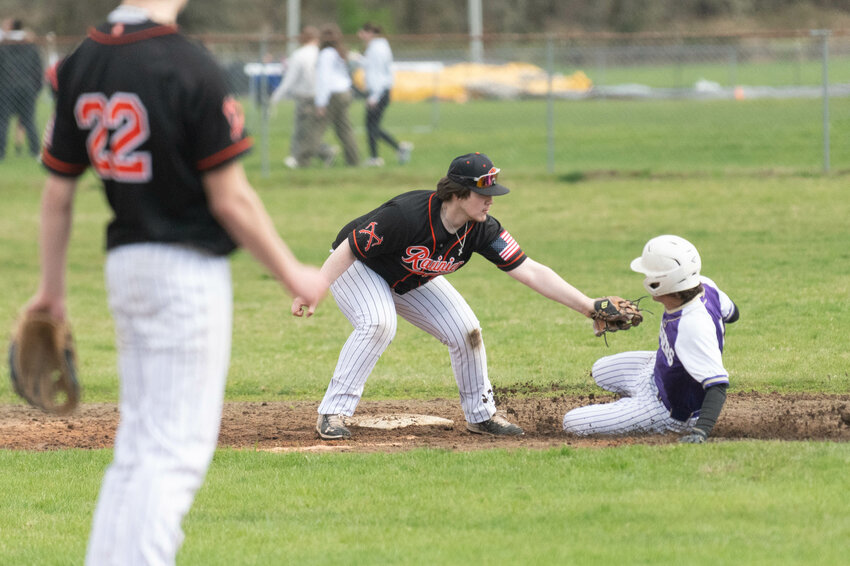 Rainier's Dayton Gardner tags out a runner trying to steal second during Rainier's win over Onalaska on April 3.