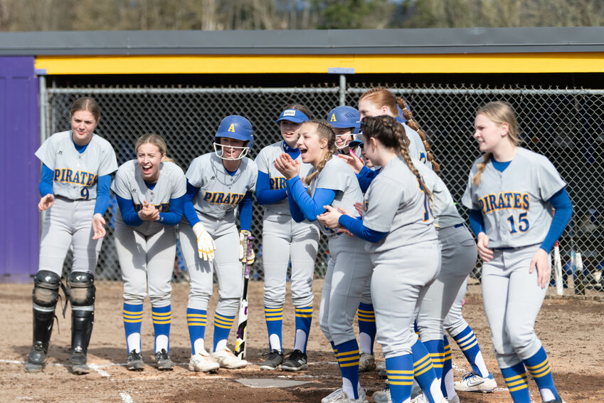 The Adna Pirates gather at home plate while Kendall Humphrey rounds the bases after she hit a home run during Adna's win over Onalaska on April 3.