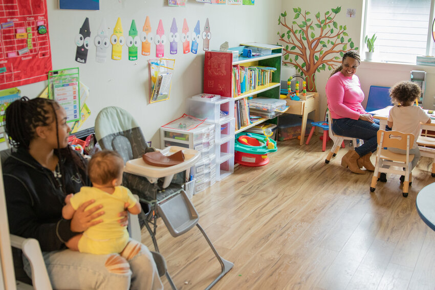 Lakeda House Family Daycare owner Lakeda Sullivan smiles at an infant being held by one of her employees, Jennifer Lipsey of Onalaska, at Sullivan's home-based daycare on Tuesday, April 1, in Onalaska.