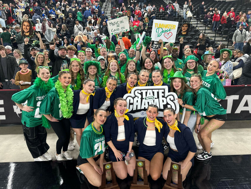 The Tumwater High School dance team poses for a photo with their three state trophies in front of their fans and families at the 2A state championships at the Yakima Valley SunDome on March 28.