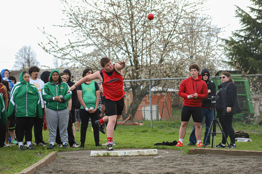 Tenino's Rowdie Tafoya chucks the shot during the shot put event at the Tenino Twilight Relays at Tenino High School on Friday, April 11.