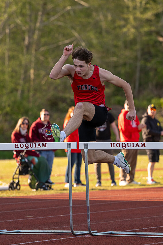 Tenino's Carson Schall leaps over a hurdle during a race at a meet in Hoquiam on April 16.