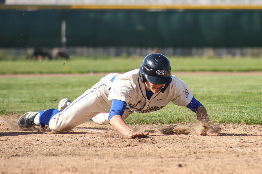 Rochester's Conley Doelman (5) slides chest first into home in game one of a doubleheader against Elma at Rochester High School on Friday, April 18.