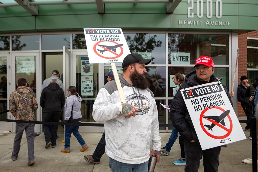 Mat Farnum, center, pickets outside Angel of the Winds Arena as striking Boeing employees pass through to vote on a contract Wednesday, Oct. 23, 2024, in Everett, Washington. (Ryan Berry for Washington State Standard)