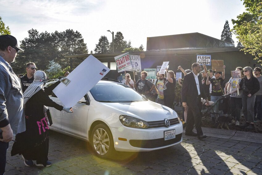 Protesters surround U.S. Rep. Marie Gluesenkamp Perez's vehicle, waving signs and shouting as she departs the venue. The scene followed a tense town hall on Thursday, April 24 marked by frustration over her votes on election reform and party discipline.