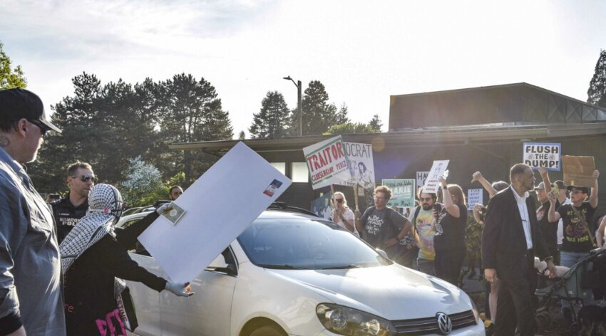 Protesters surround U.S. Rep. Marie Gluesenkamp Perez's vehicle, waving signs and shouting as she departs the venue. The scene followed a tense town hall on Thursday, April 24 marked by frustration over her votes on election reform and party discipline.