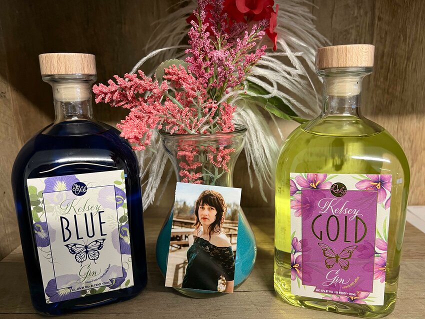 Kelsey Buchanan is pictured between two bottle of Kelsey Gins.