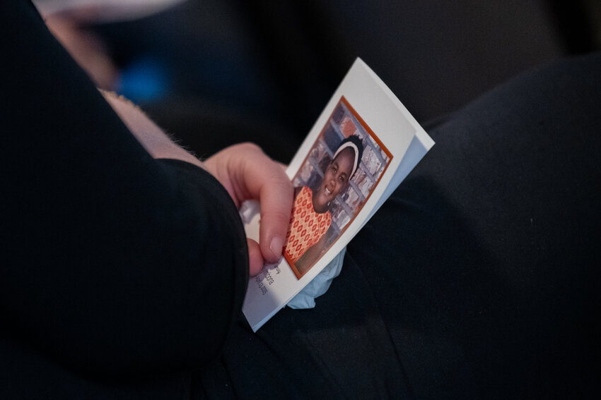 An attendee holds a program as they listen to Sarah Niyimbona's tribute at Sarah's  funeral at Riplinger Funeral Home & Crematory on Tuesday, April 22, 2025, in Spokane, Wash.