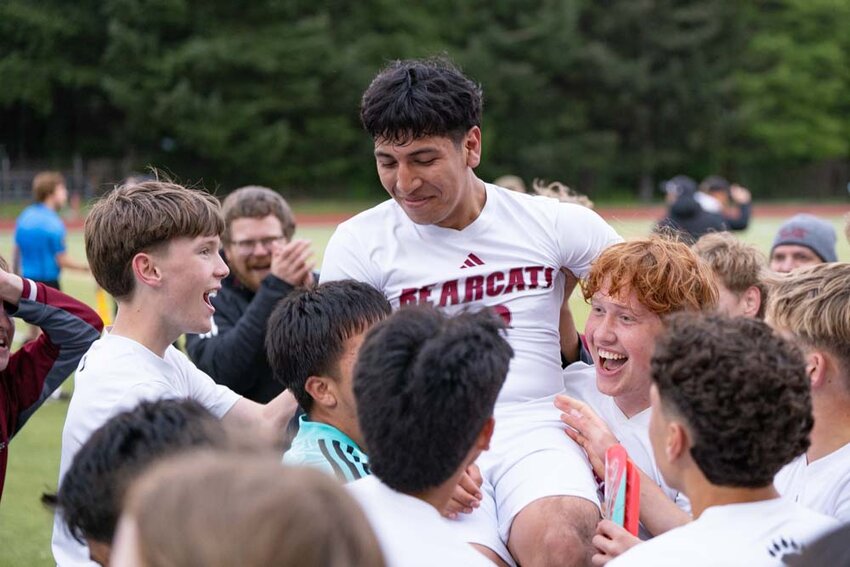 W.F. West teammates raise Moises Sanchez-Hernandez in the air after he headed a shot to score the winning goal and send The Bearcats to the State Tournament during a District 4 Tournament Semifinal win over Tumwater at Tumwater High School on Tuesday, May 13.