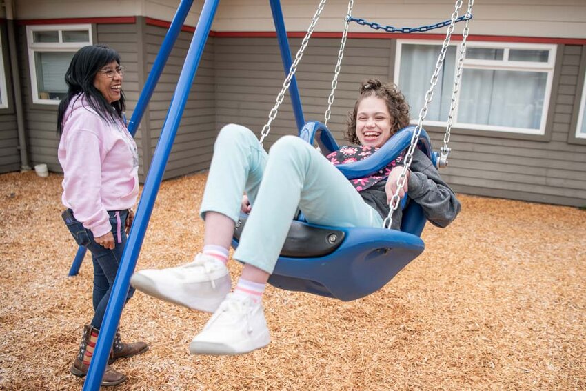 Student Bella Axtmann smiles while swinging on the new swing set during an opening and blessing ceremony by the Chehalis Tribe for the new accessible playground at Rochester Middle School on Thursday, May 15.