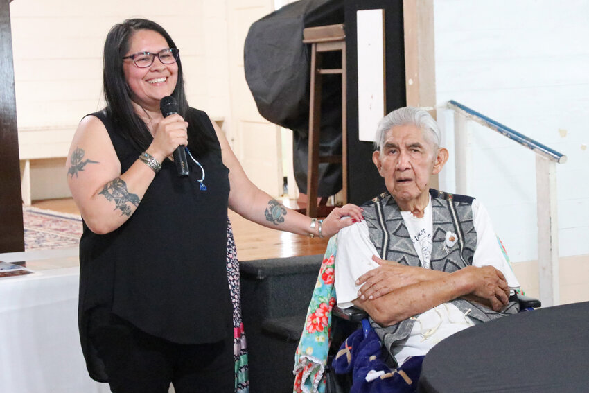Heather Walker-Taylor places a hand on her grandfather Mel Youckton's shoulder as she speaks about him during a celebration at Swede Hall in Rochester on Saturday, May 17.
