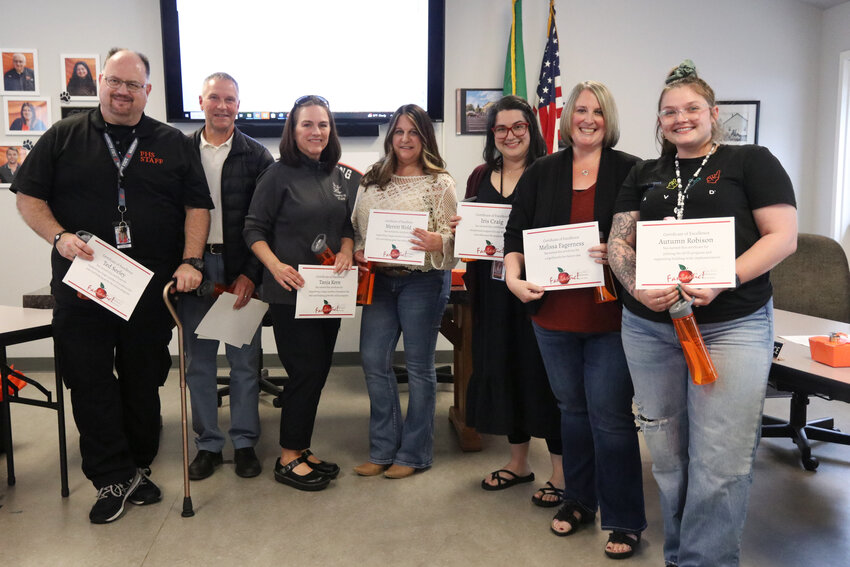 From left, teachers Ted Seeley, Brady Churchill, Tanja Kern, Merrit Wold, Iris Craig, Melissa Fagerness and Autumn Robison pose for a photo with certificates of excellence after being recognized at a Centralia School Board meeting on Thursday, May 22.