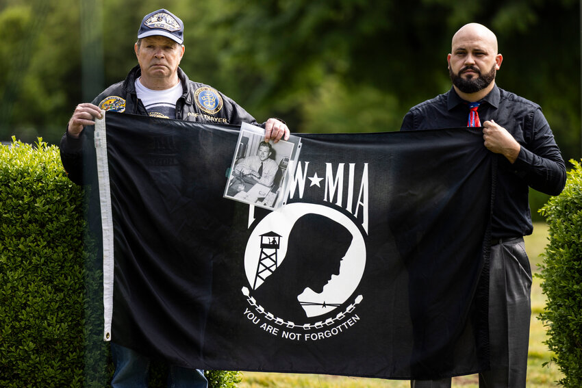 U.S. Army veteran Geoff Moore, right, and U.S. Navy veteran Robert Thayer hold a POW MIA flag during a Memorial Day ceremony at the Claquato Cemetery in Chehalis on Monday, May 26. Thayer&rsquo;s father, John Thayer, went missing in action Jan. 7, 1961.