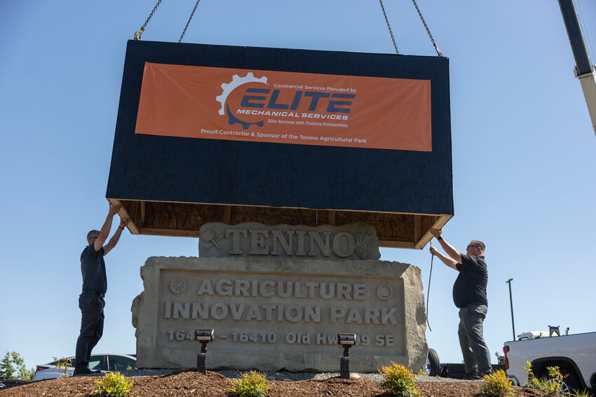 A box lifted by a crane reveals the new sandstone monument for the Agriculture Innovation Park during it&rsquo;s grand opening in Tenino on Wednesday, May 28.