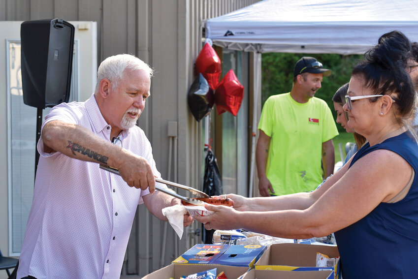 Pastor Bill Smith passes hot dogs to guests during a celebration on May 29 at Grace Lodge. The Clark County Council recently approved a five-year lease renewal, allowing XChange Recovery to continue its transitional housing program for women overcoming addiction.