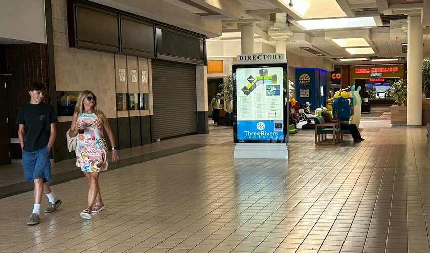 Two people walk toward a Three Rivers Mall exit on Thursday, June 5 in Kelso.
