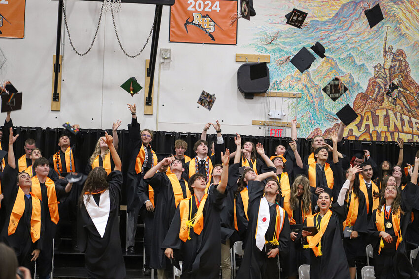Members of the Rainier High School Class of 2025 toss their caps into the air during the graduation ceremony on Friday, June 6.