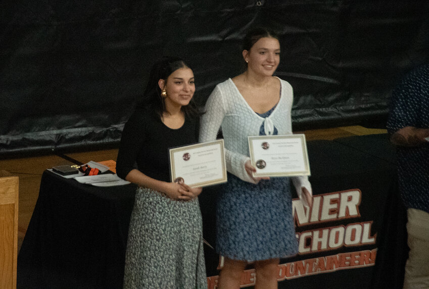 Sarah Barry, left, and Bryn Beckman, receive certificates at senior awards night at Rainier High School on Tuesday, June 3.