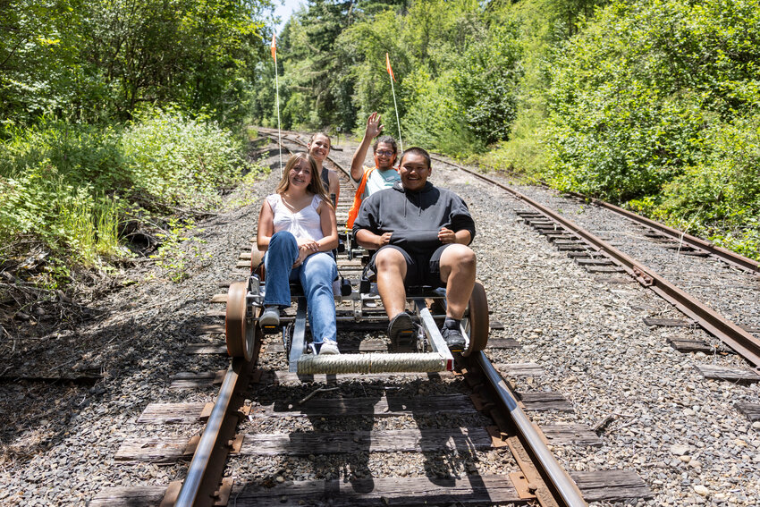 Makenna Horst, left, Crystal Hauth, back left, staff member Trevontae Scharber and Jorge Leal pedal their Joy Rails rail car along the Centralia-Chehalis Railroad on Tuesday, June 10.