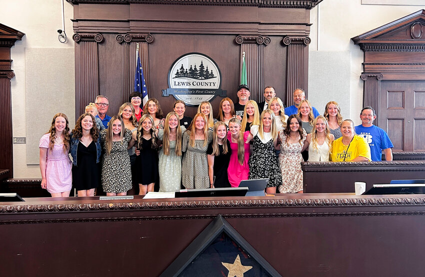The Adna softball team is recognized for their third consecutive Class 2B state championship win in Yakima during a commissioners meeting at the Lewis County Courthouse in Chehalis on Tuesday, June 10. Coaches, players and commissioners gathered for the photo after each player said her name.