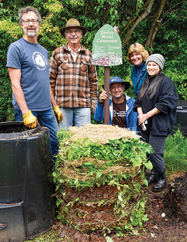 Volunteers pose with a finished compost pile, freshly layered with greens and browns, during a workshop held last week at the Center of Agriculture, Science, and Environmental Education. The bin was removed to show the mix. In roughly four months, this pile will become nutrient-rich soil.