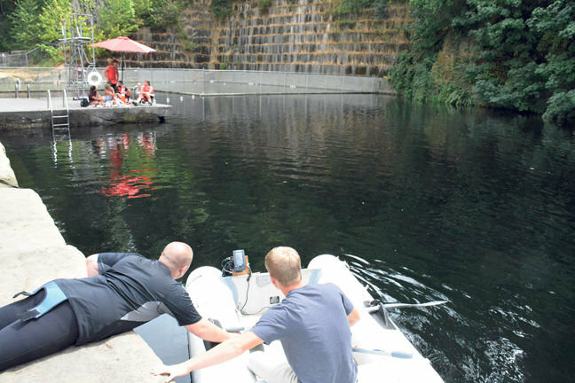 Wayne Fournier, left, reads a depth scanner at the Tenino Quarry Pool during a dive expedition to the bottom of the pool in 2017.