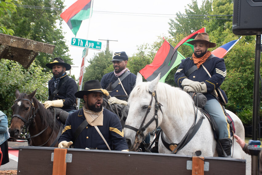 The Buffalo Soldiers of Seattle sit on their horses behind CEO and program director Geordan Newbill at the annual Juneteenth Celebration at Rebecca Howard Park in Olympia on Saturday, June 21.