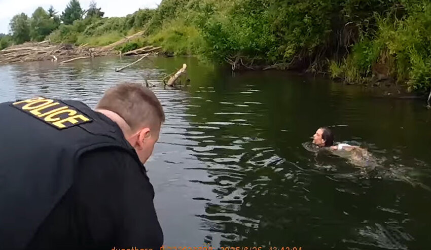 Centralia police officers Deter Voetberg and Franklyn Ramos, left, approach the fleeing suspect in the Chehalis River on June 25.
