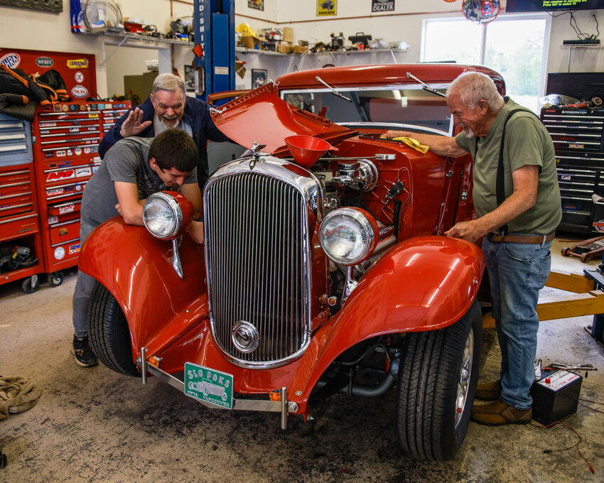 Lonnie Moss, right, owner of a 1932 Plymouth PB Three Window Coupe, friend Don Brissler and grandson Zachory Zamora all share a laugh when giving the engine compartment a look on Thursday, July 10.