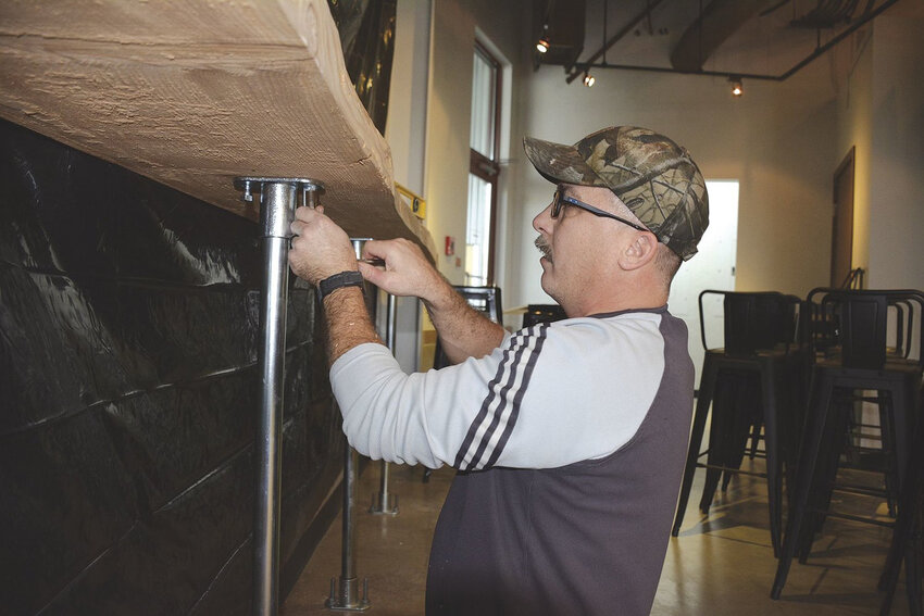 507 Taproom owner Bill DeVore works on his bar at the original location, prior to its opening in 2019.