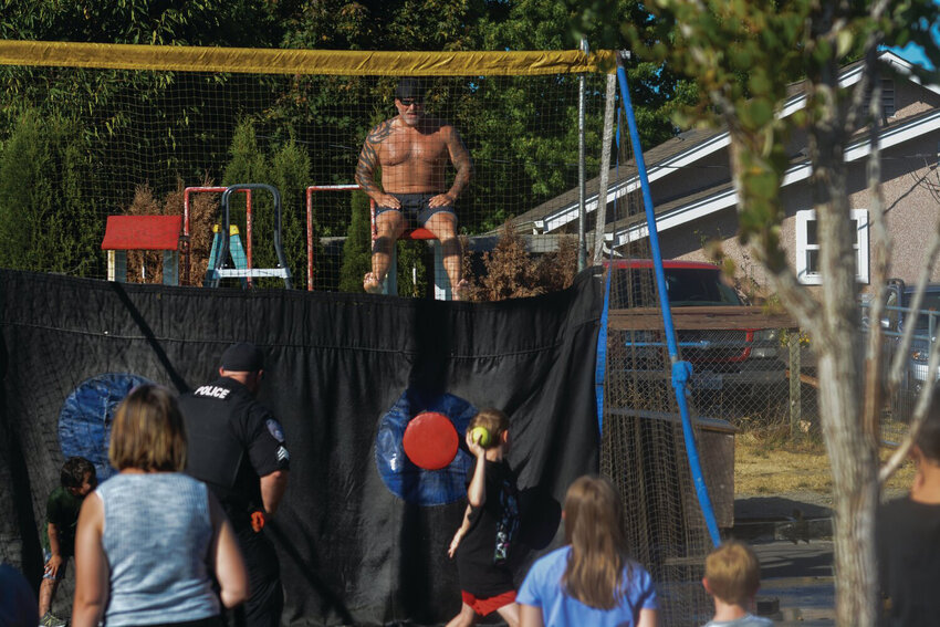 A young attendant of Yelm&rsquo;s National Night Out on Aug. 1 attempts to submerge Police Chief Rob Carlson in a dunk tank.